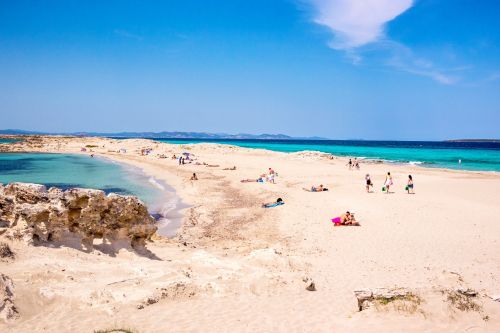 People relaxing on the beach of Ses Illetes in Formentera, Spain
