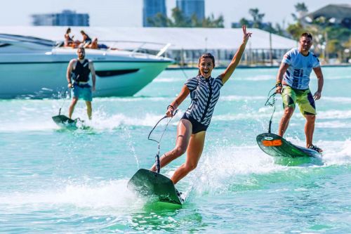 A woman and two men jet surfing