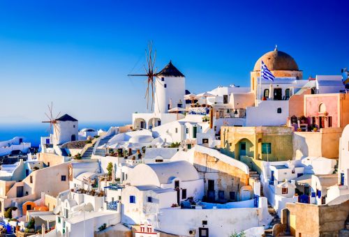 Fira, the capital of Santorini, with its whitewashed houses and mills under a beautiful blue sky