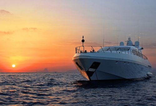 A luxury charter yacht at anchor at sunset