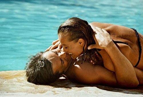 Romy Schneider and Alain Delon kissing near a pool in the movie The Swimming Pool