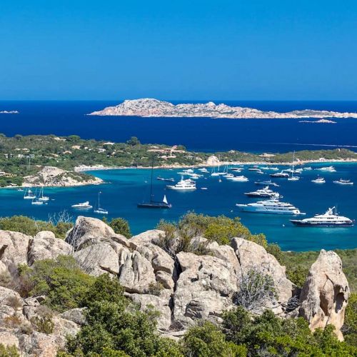 The bay of Cala di Volpe in Sardinia with luxury charter yachts at anchor