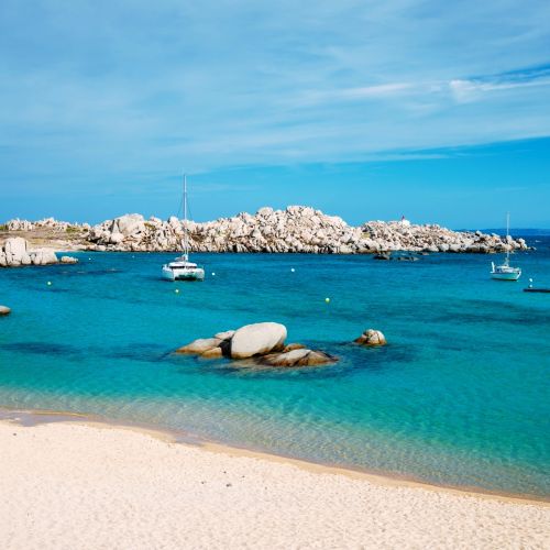 Cala Acciarino, the most beautiful beach of the Lavezzi Islands in Corsica, with a catamaran at anchor