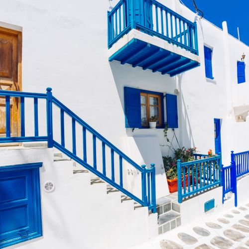 A street in Mykonos with whitewashed buildings and blue details typical of the Cyclades islands in Greece