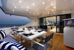 The aft deck of a yacht with a table set up for dinner