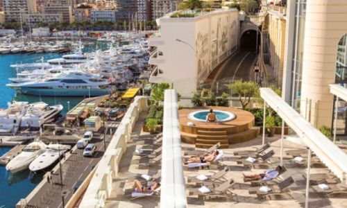 The solarium of the Thermes Marins de Monte-Carlo with a view of Port Hercule and its luxurious moored yachts