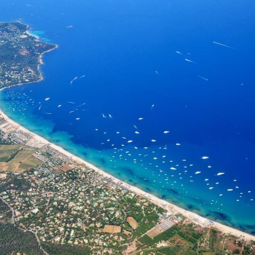 The sandy beach of Pampelonne in Ramatuelle, close to St Tropez, and luxurious charter yachts at anchor