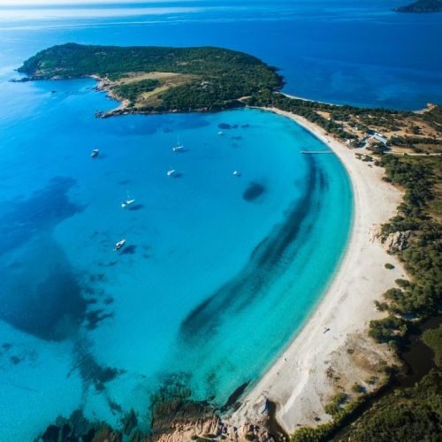 Aerial view of the gorgeous Rondinara beach in Corsica with charter yachts at anchor