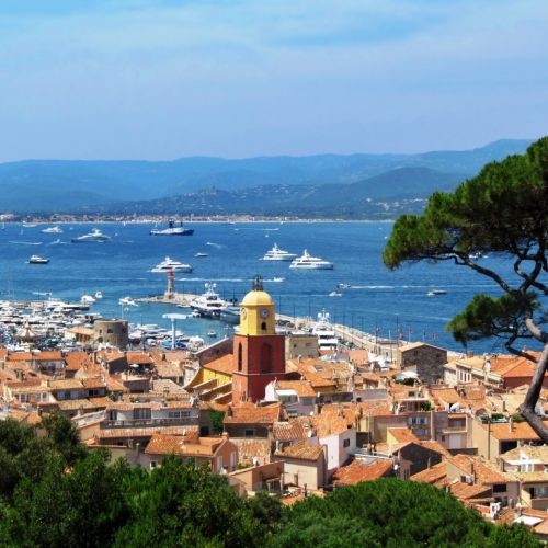 The village of St. Tropez with its beautiful bell tower and charter yachts at anchor in the bay