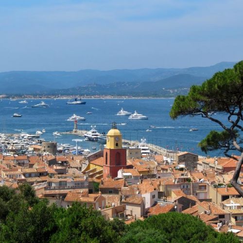 The village of St Tropez and its bell tower with yachts anchored in the bay