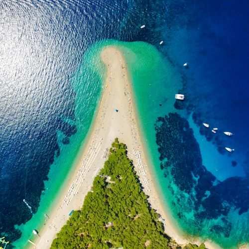 Aerial view of the unique beach of Zlatni Rat in Croatia with yachts at anchor