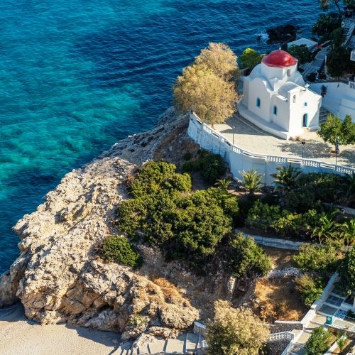 The beautiful monastery of Kyra Panagia with its red dome and the turquoise waters of the Mediterranean sea