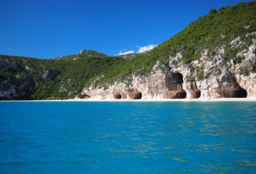 View on the beach of Cala di Luna with its rocky cavities in the gulf of Orosei in Sardinia 