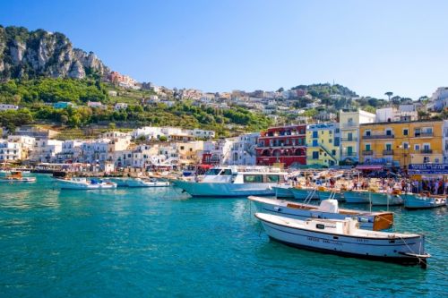 The small port of Capri with its boats and colourful houses under a beautiful blue sky