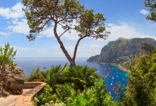 The coastal path of the island of Capri with a view of the Mediterranean sea and yachts at anchor