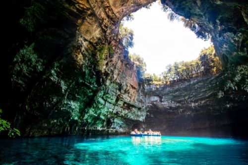 People on a boat exploring the impressive Melissani Cave on the island of Kefalonia in Greece