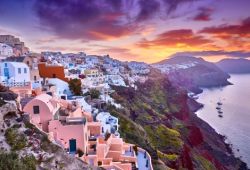 The village of Oia on the island of Santorini with a beautiful sunset and pink reflections on the houses