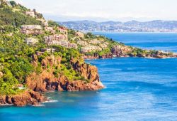 A bay in Thoule-sur-mer with the red rocks of the Esterel massif and the waters of the Mediterranean sea