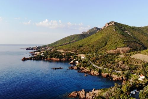 The beach of La Pointe de l'Aiguille in Thoule-sur-mer with the red rocks of the Estrel 