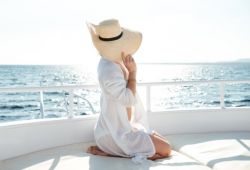 A woman with a hat sunbathing on her honeymoon aboard a yacht