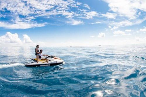 A couple using a jet-ski during their luxury yacht charter