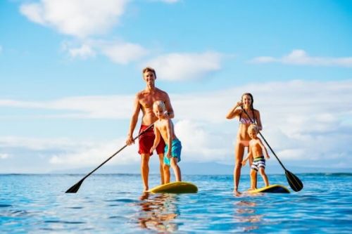 A family playing with paddle boards