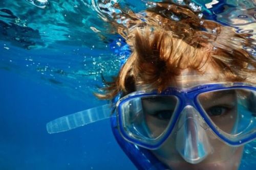 A boy snorkeling with mask and snorkel