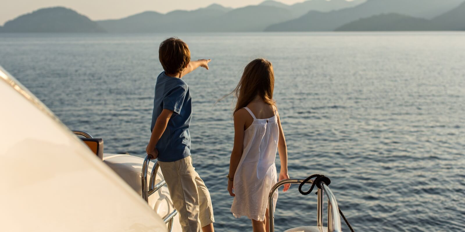 https://www.talamare.com/medias/Kids looking at the sea from a charter yacht with their parents on the aft deck