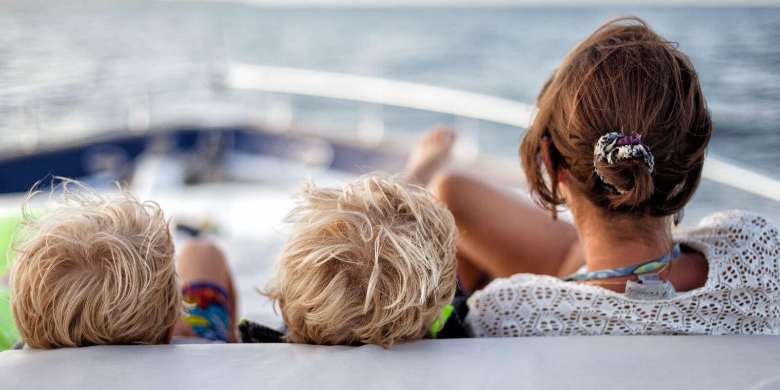 https://www.talamare.com/medias/A woman with kids relaxing on the foredeck sun pads of a family-friendly charter yacht