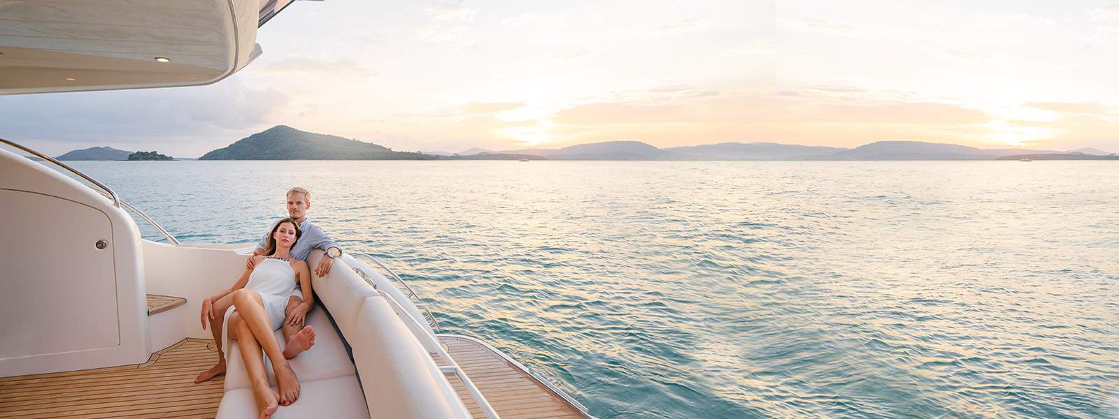 A couple relaxing on the aft deck of a charter yacht